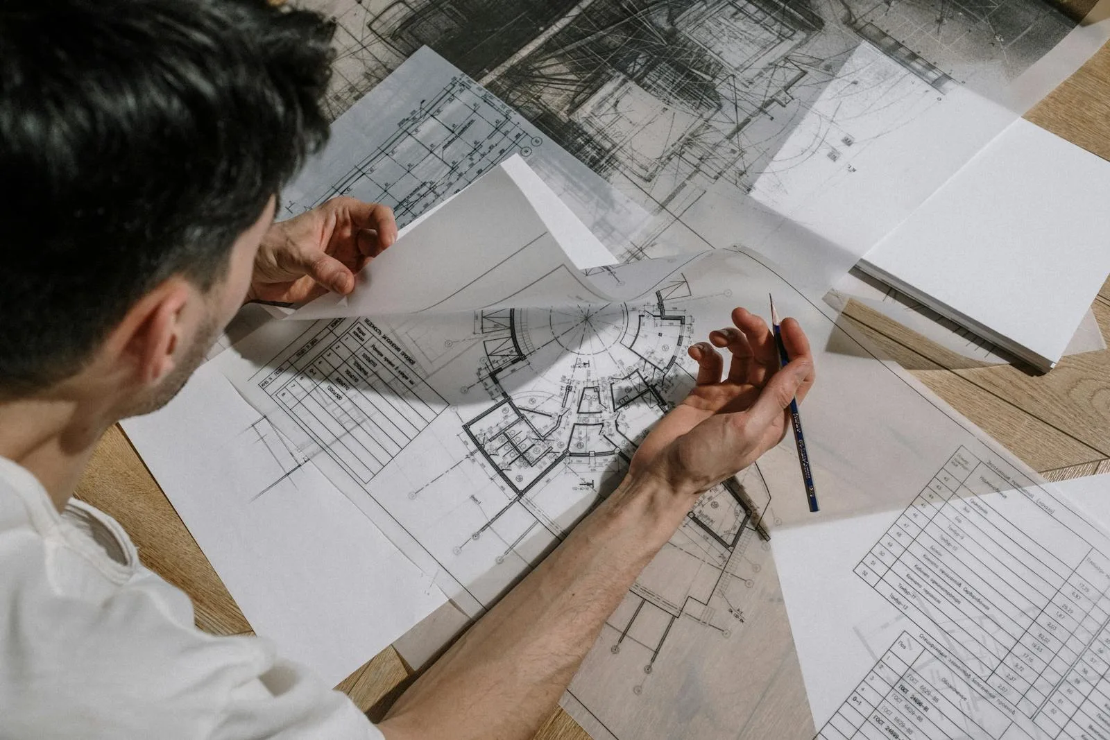 Planer arbeiten mit Bleistift und Lineal an Bauzeichnungen